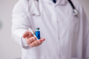 Young male doctor in vaccination concept