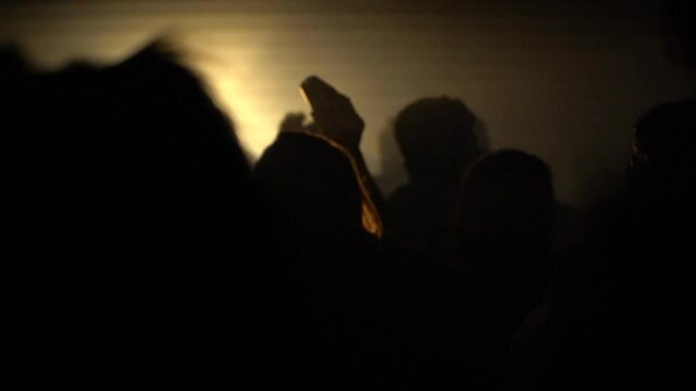 Flashing lights and close up view of person back head, nightclub party