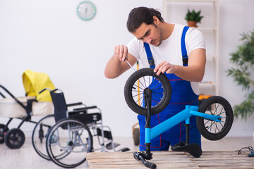 Obraz premium Young male repairer repairing bike indoors