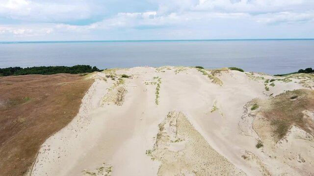 Panoramic viewing point of Curonian lagoon on sandy dune end, aerial drone fly backward view