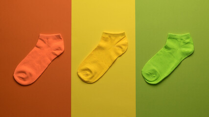 Three colored socks on a background of three colors.