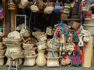 A pile of handmade traditional woven baskets made from natural fiber along with halters and bridles...