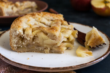 Freshly cut apple pie, with a wooden fork and dark background. Super close up.