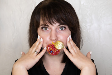 Portrait of a young woman with a handmade brooch on a light background. Facial expression, selective focus, beautiful people. 