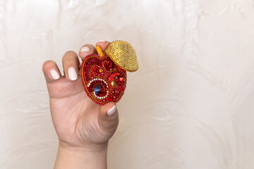 A woman's hand holds a beaded brooch. The elegance and beauty of handicrafts. 
