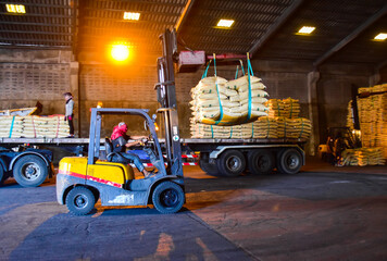 Warehouse intake, forklift carrying sugar bags from truck to stack inside a warehouse. Sugar,...