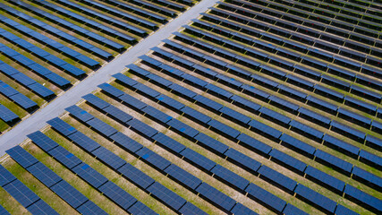 Aerial view above of solar panels in solar cell field to create the clean electric power industrial from nature. Drone shot.