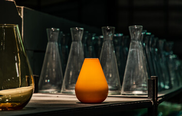 A display of yellow glass vases on the shelf at Glassware warehouse. Concept of interior design and decoration. Copy space, Selective focus.