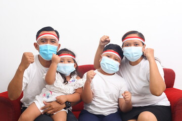Asian family celebrate Indonesia's independence day during the pandemic. They wearing a face mask. Isolated on white background