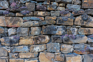 Wall of real stone for background, typical construction of the rural world and of the mountain areas.