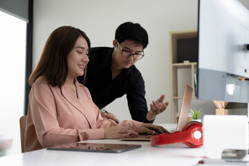 Businessman and businesswoman discussing company business together in office.