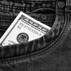A hundred-dollar bill in the pocket of his jeans. The one hundred American dollar bill is sticking...