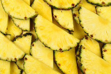 Pineapple juicy yellow slices background. Top view.