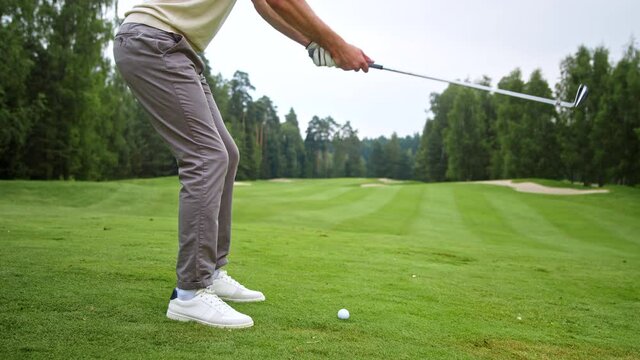 Young golfer in uniform making a hit with a club