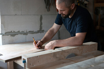 the carpenter marks out the board for further work