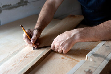 the carpenter marks out the board for further work