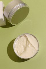 Aluminum cosmetic jar on green background