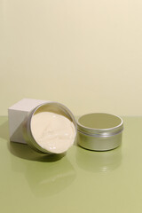 Aluminum cosmetic jar on green background