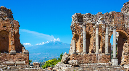 Griechisch-römisches Amphitheater in Taormina, Sizilien, mit rauchendem Vulkan Ätna im Hintergrund