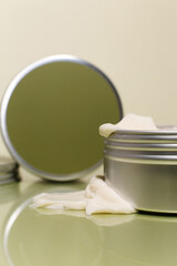 Aluminum cosmetic jar on green background