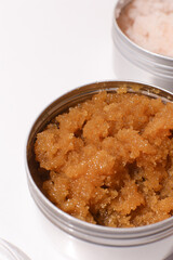 Body scrub of oatmeal, sugar, honey and oil in melat eco jar on white table, homemade cosmetic for peeling and spa care