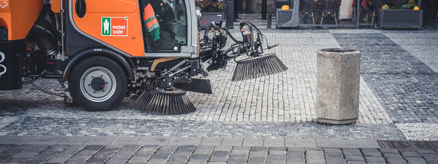 Sweeper machine in the process of cleaning the street.. Municipal service cleans the city.
