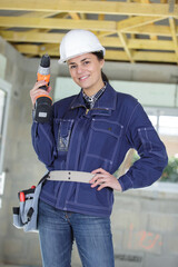 young woman worker holds an electric drill