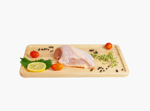 Raw chicken breast on wooden cutting board isolate white background.