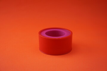 Stock photo of insulation or orange colored plaster in a circle. Isolated on an orange background. Stationery and office industry, design, website photos.