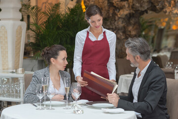 couple ordering meal to waitress at gourmet restaurant
