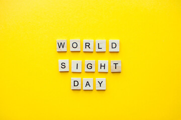 The inscription world sight day from wooden blocks on a bright yellow background. High quality photo