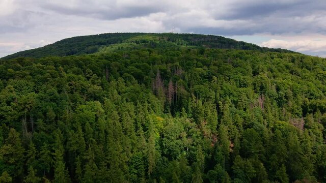 Drone flight over mountain village with forests. Sleza mountain near Wroclaw in Poland. Nature background, aerial view