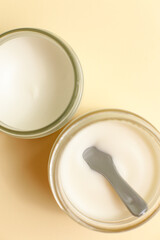 Moisturizing cosmetic cream stands on neutral background with milk splash
