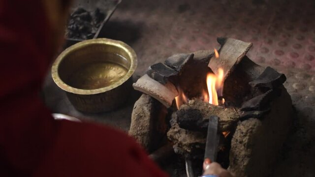 A indian woman preparing clay stove for food selective focus.