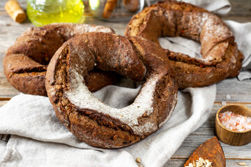 Rye flour bagels on a light gray wooden background. Delicious and healthy homemade bread closeup