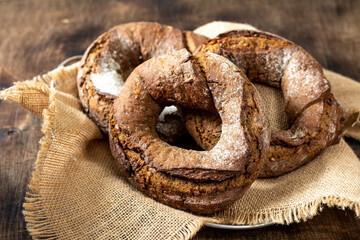 Rye flour bagels in a basket on a brown wooden background. Delicious and healthy homemade bread...