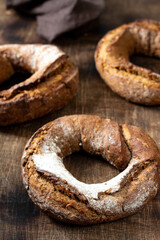 Rye flour bagels on a brown wooden background. Delicious and healthy homemade bread closeup