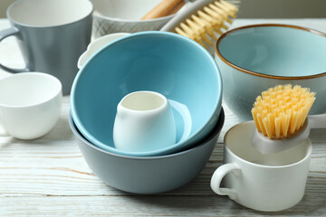 Concept of dish washing on white wooden table