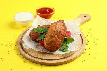 Concept of tasty food with cutlets on yellow background