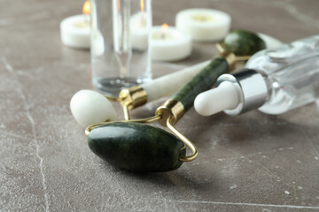 Skin care concept with face rollers on gray textured table