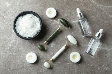 Skin care concept with face rollers on gray textured table