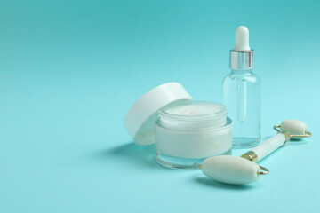 Skin care concept with face roller on blue background