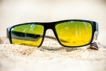 Sunglasses are lying on the sea beach