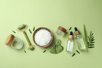Skin care beauty concept with face roller on green background