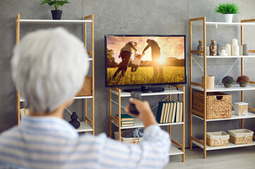 Senior woman watching photo collection of her life memories, family, children and grandchildren, or...