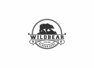 logo illustration of a bear walking on a rock on a white background