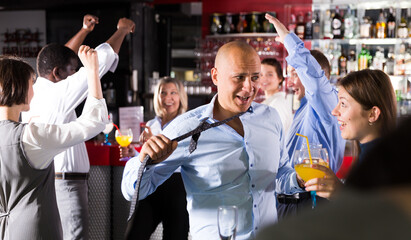 Portrait of man in unbuttoned shirt dancing at corporate party