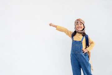 dreams of flight! little child girl playing with a pilot hat on white background