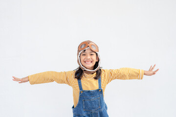 dreams of flight! little child girl playing with a pilot hat on white background