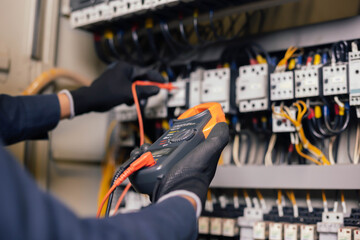 Electrician engineer work tester measuring voltage and current of power electric line in electical...